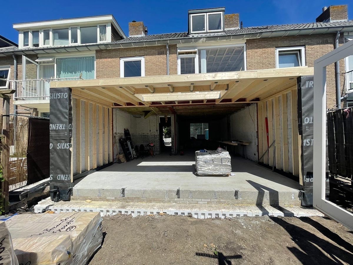 Woning met opengebroken achtergevel en aanbouw in uitvoering.
