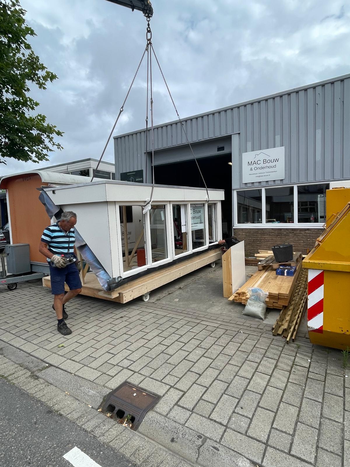 Prefab dakkapel die buiten een bedrijfspand wordt verplaatst.