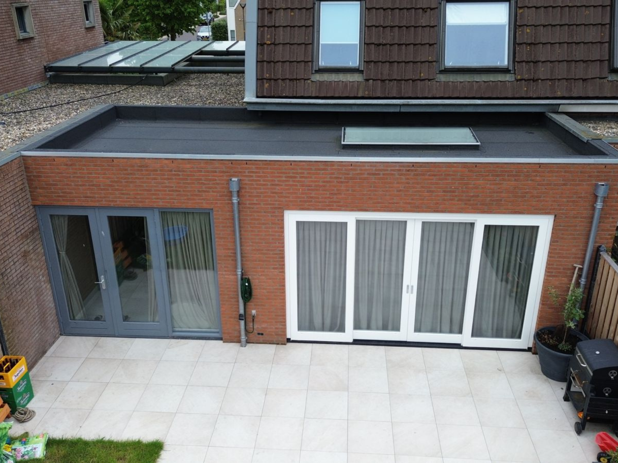 Achtergevel van een woning met openslaande deuren en terras